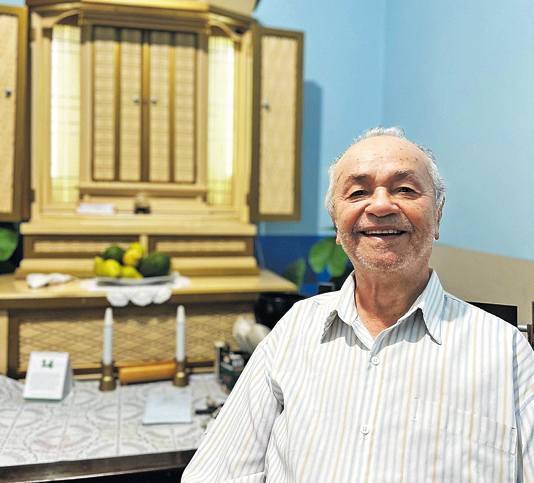 foto Sr Joel sorrindo, em frente ao oratório budista